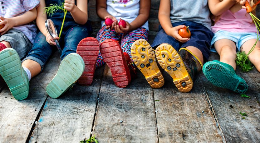 Becoming Sons and Daughters of God; photo of children sitting on a wooden deck as a figurative illustration of children of God