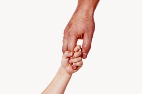 Photo of a father's hand holding a small child's hand to illustrate the article Fumbling Through Parenthood: What Becoming a Dad Has Taught Me About God