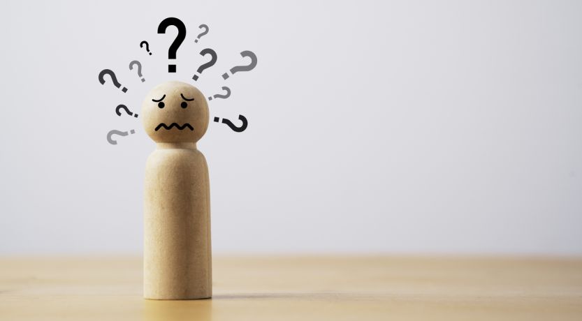 Graphic of a wooden figure with many question marks around his head to illustrate the article How Do You Handle Why?